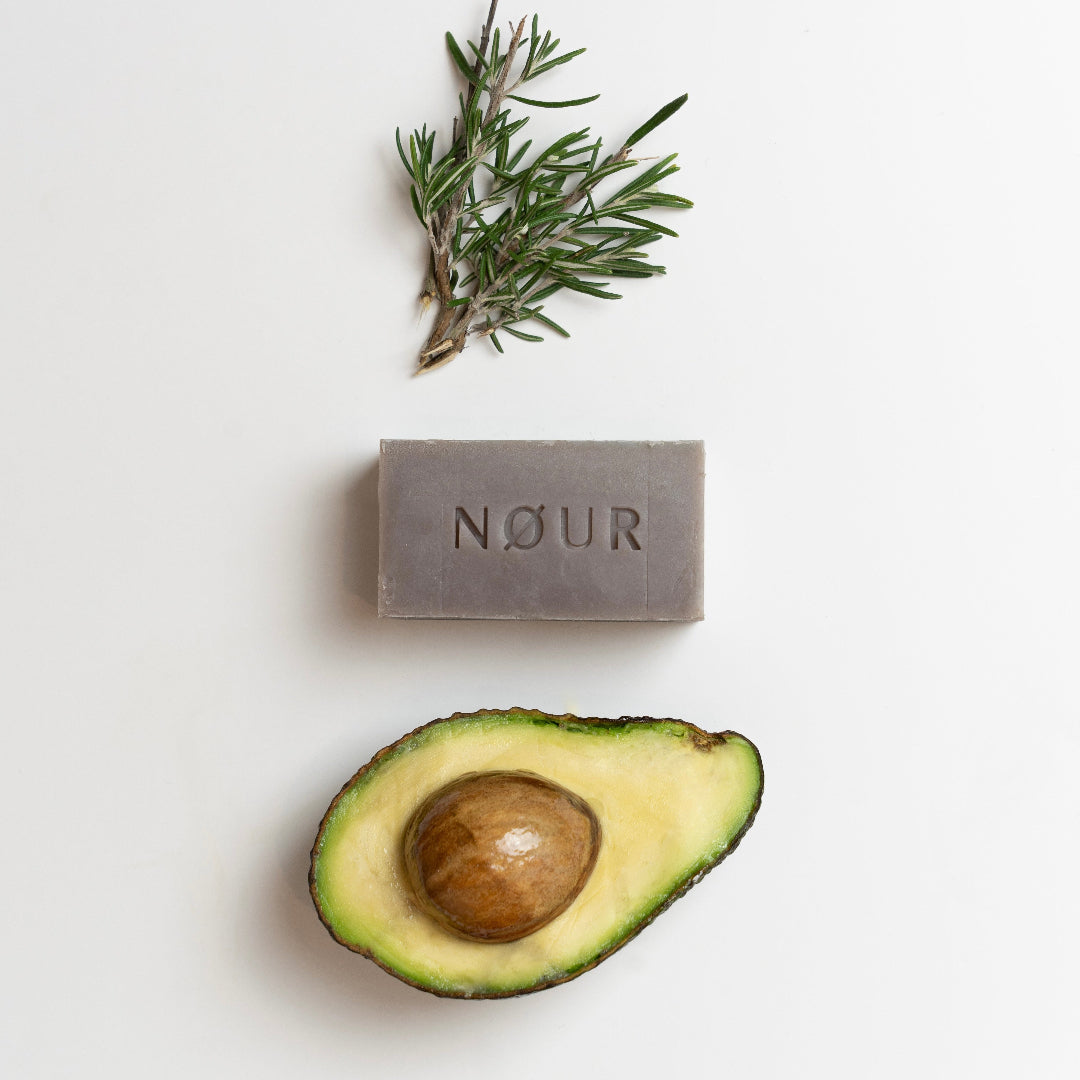 nour Seife lemon balm mit halbierter avocado und rosmarinzweig dekoriert
