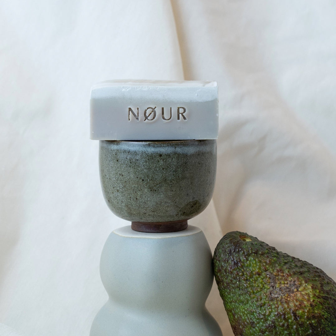 nour seife mud dekoriert auf tonschale und avocado