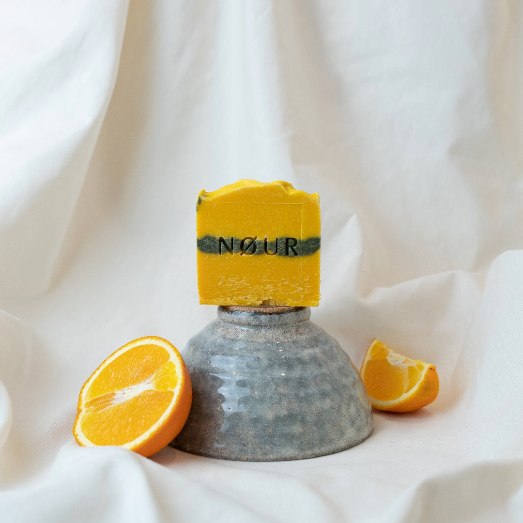 nour seife pumpkin spice auf grauer keramikschale und mit orangen dekoriert