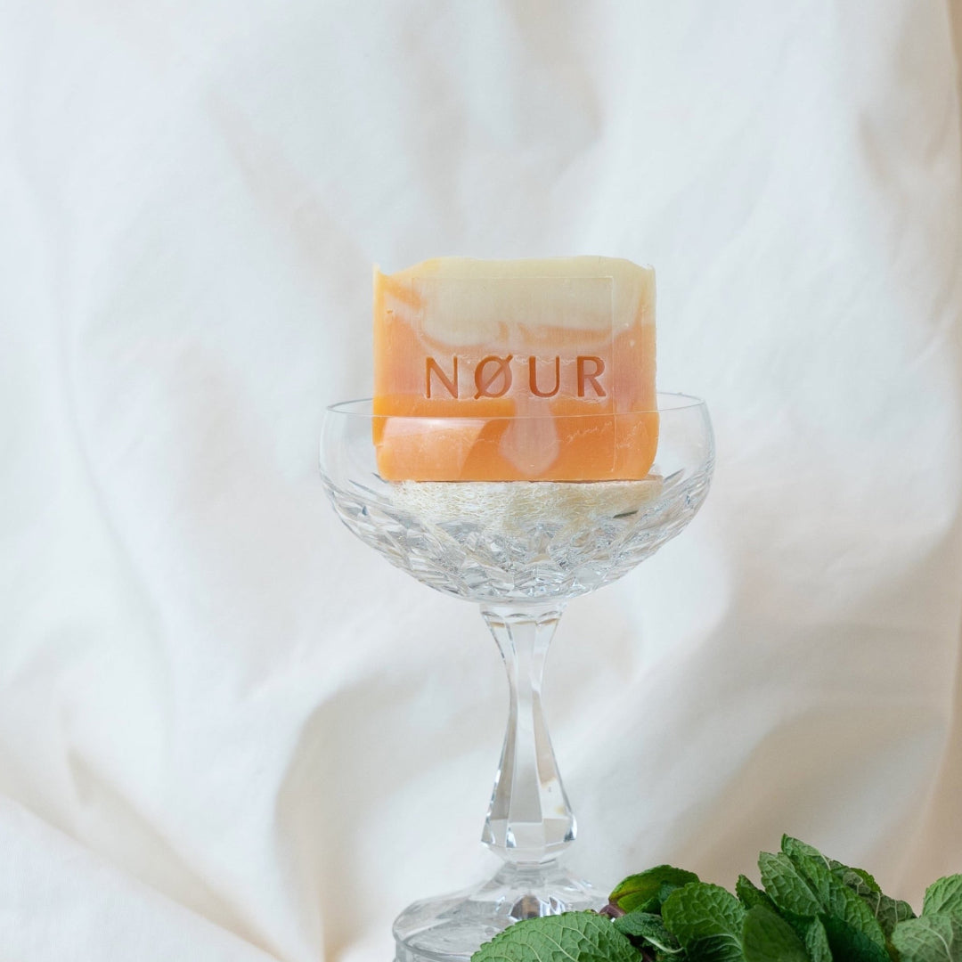 Sundowner nour seife dekoriert im kristallglas und mit minzblaettern