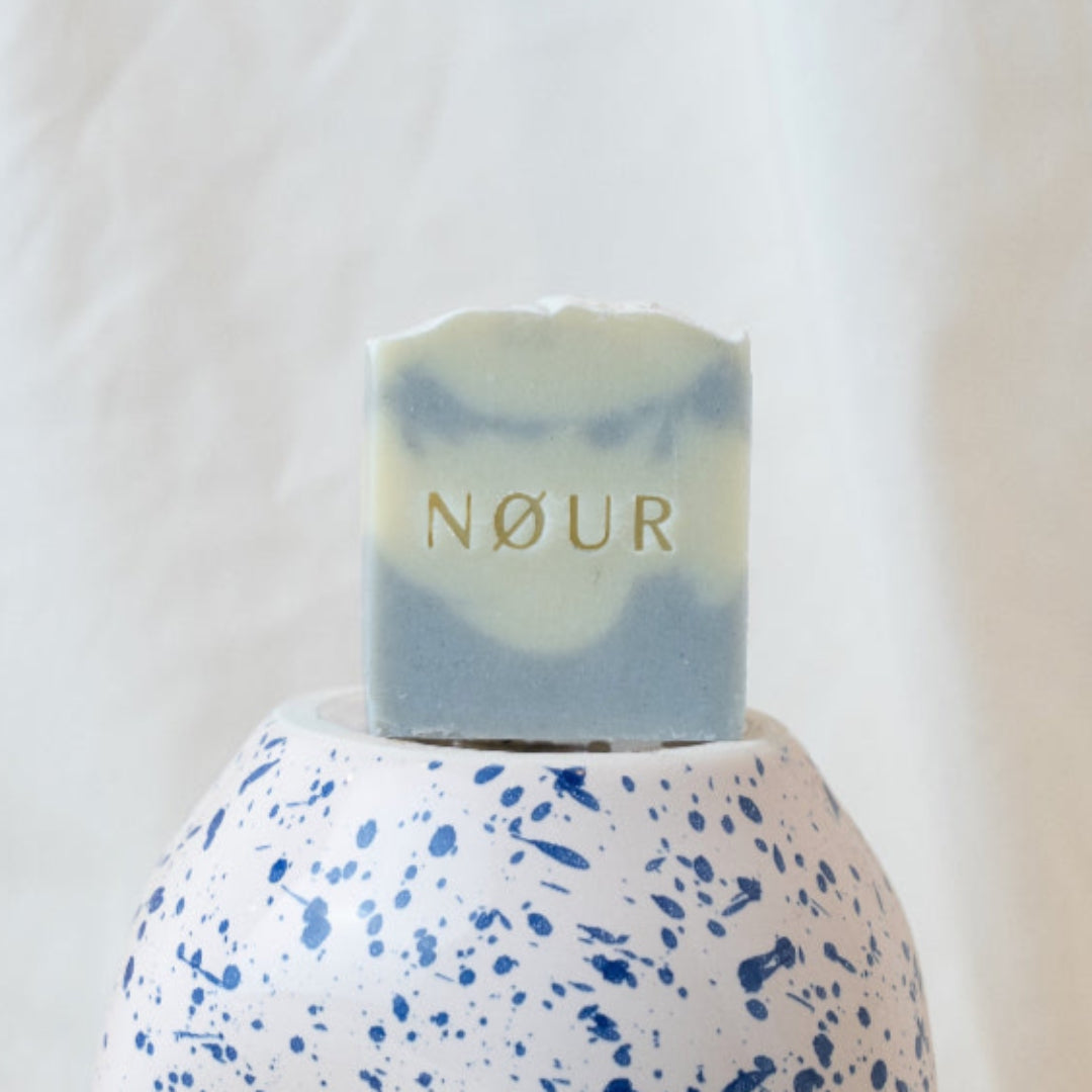 nour seife cloud auf blau weissem tongefaess mit halber avocado