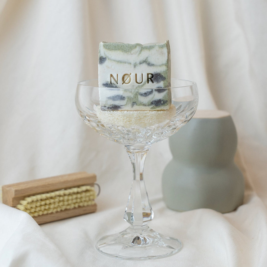 Naturseife lavender swirl von nour seife mit lavendelduft bioseife bei angespannter haut im Cocktailglas und Handwaschbürste