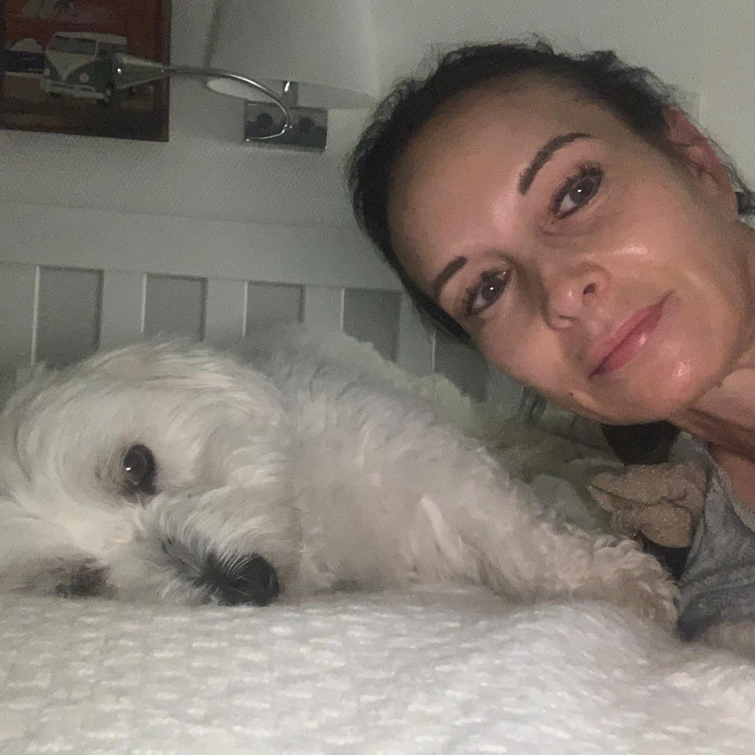 frisch gewaschener Hund mit Frauchen im Bett