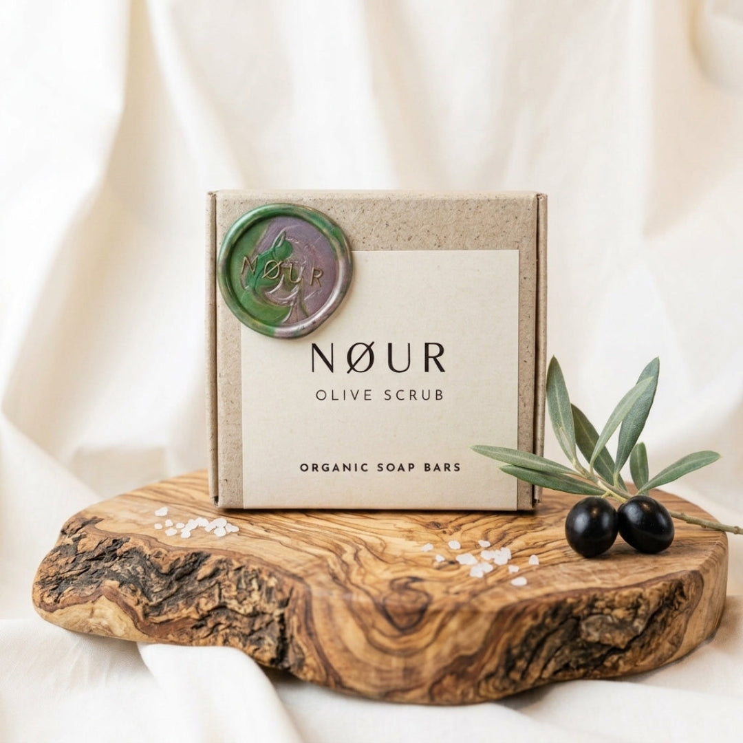 Verpackung von Olive Scrub auf einem Olivenholzbrett mit Oliven und Salz